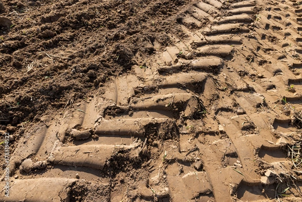 Fototapeta traces of a tractor on the soil during tillage, soil in a field with traces of passing heavy agricultural machinery after tillage