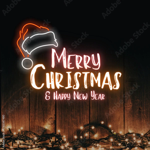 Fototapeta Merry christmas and happy new year neon sign with santa hat and string lights on wood background