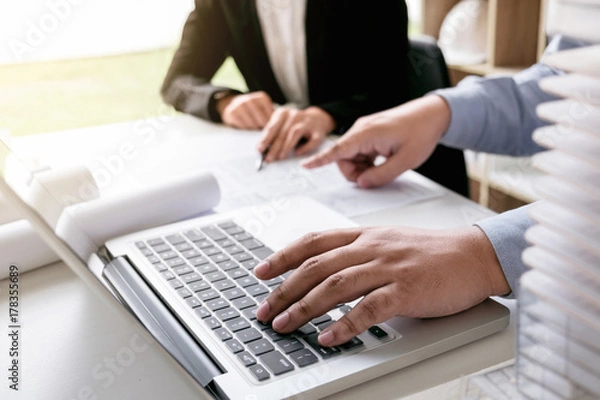 Fototapeta Engineering or Creative architect in construction project, Engineers hands working on construction blueprint and building model at a workplace in office, Building and architecture concept