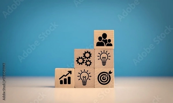 Fototapeta Wooden blocks with business icons representing growth, ideas, and teamwork on blue background.