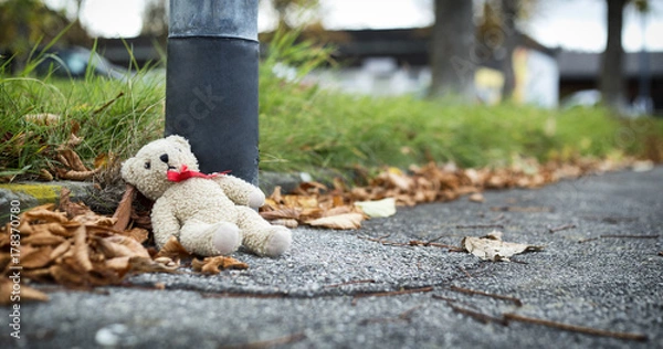 Fototapeta Teddy bear thrown near the pillar