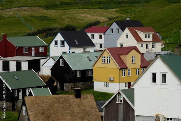 Fototapeta Traditional Nordic-style houses in Gjógv, Faroe Islands, showcasing colorful rooftops and coastal charm — ideal for travelers exploring hidden northern gems.