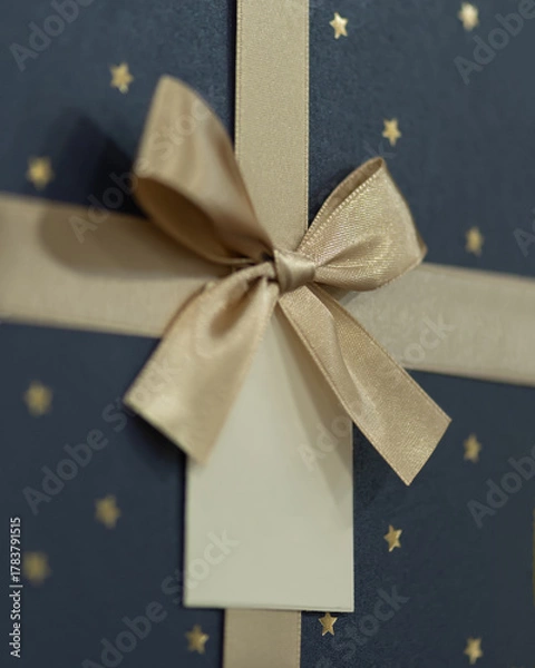 Obraz Close up of elegant gift box with golden ribbon and tag
