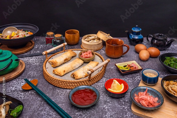 Fototapeta Still life with spring rolls fused with Mexican ingredients, served with avocado sauce and garnished with black sesame seeds and microgreens