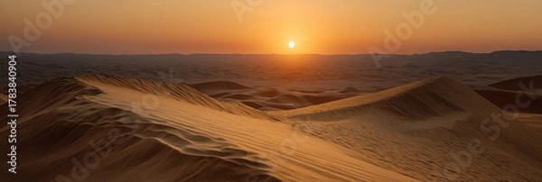 Obraz The sun sets over a vast sandy desert, casting warm hues across the dunes, creating a breathtaking and serene natural landscape that evokes feelings of isolation and beauty.