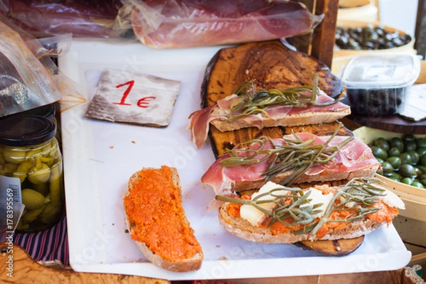 Obraz Bred with olive oil (pa amb oli) with jamon, sobrasada and Majorcan herbs for sale at Sineu market, Majorca, Spain