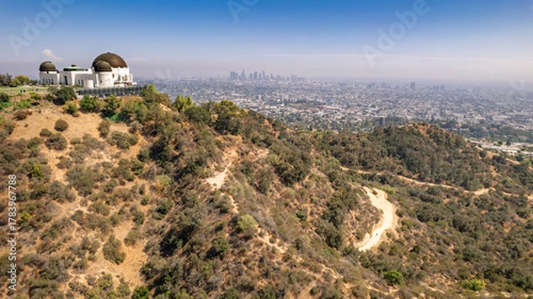 Fototapeta Panoramic view of Griffith Observatory overlooking Los Angeles skyline. Rolling hills, hiking trail, clear blue sky, urban landscape, California scenery, majestic dome structure, perfect day shot.