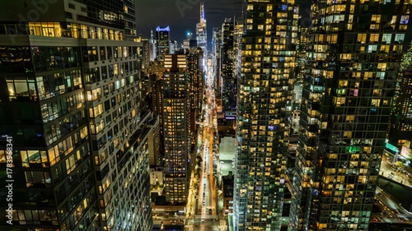 Fototapeta Panoramic view of a dense city skyline at night. Thousands of windows glow with light, creating a mesmerizing pattern. Ideal for marketing, technology, or business themes.