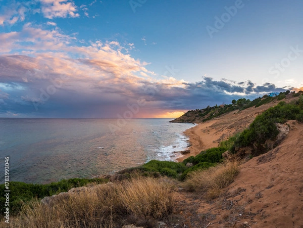 Fototapeta Golden sandy beach of Le Cannella Capo Rizzuto Calabria Italy with turquoise waters rocky shoreline and sunset sky symbolizing freedom nature serenity and Mediterranean summer allure.