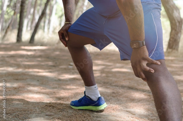 Obraz Black man doing leg exercise in nature