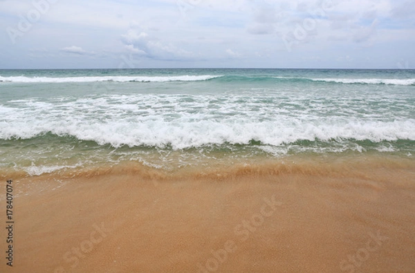 Fototapeta Ocean wave on sandy beach.