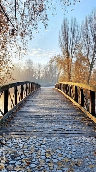 Obraz Wooden bridge over a misty river, autumn leaves