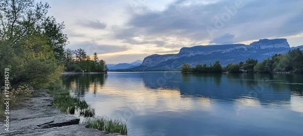 Fototapeta Tranquil lake reflecting a serene mountain vista at twilight