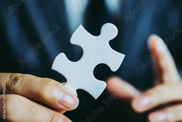 Fototapeta パズルのピースを持っているビジネスマン