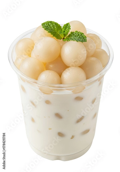 Obraz A clear plastic cup filled with a creamy, pale white dessert or drink, topped generously with plump, translucent white rambutan arils