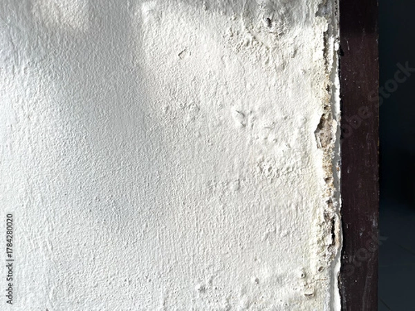 Fototapeta Shadow of broken washbasin drain pipe on damped, musty old painted wall with sunlight. Closeup textured exterior toilet wall in room at dhamma retreat center, Saraburi, Thailand. 25 OCT 2025. A.M.