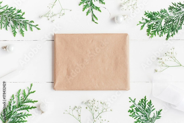 Obraz Christmas frame. Christmas gift, gypsophila flowers, thuja branches on white wooden background. Flat lay, top view, copy space