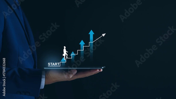 Fototapeta Startup business. Businessman starting an online company. Planning his business, trade, profits, future investment on tablet virtual screen. Startup to success business. digital planning technology.