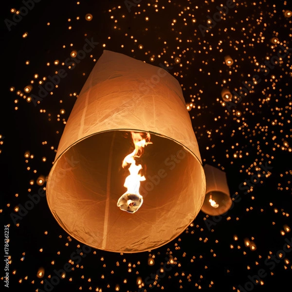 Obraz hundreds of paper lanterns glowing in the night sky during yi peng festival in chiang mai, thailand, as warm flames lift them gently, symbolizing wishes and letting go.