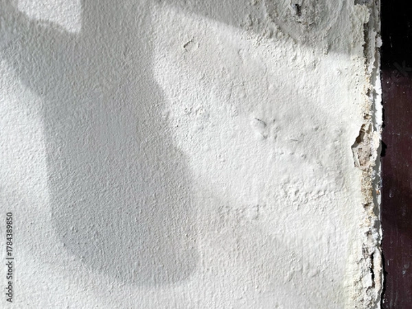 Fototapeta Shadow of broken washbasin drain pipe on damped, musty old painted wall with sunlight. Closeup textured exterior toilet wall in room at dhamma retreat center, Saraburi, Thailand. 25 OCT 2025. A.M.