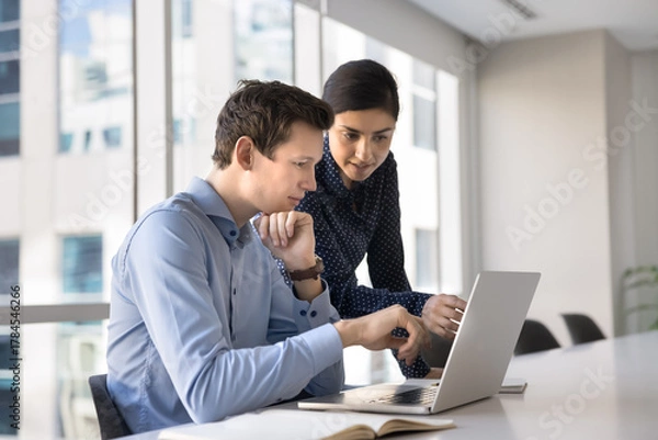 Obraz Experienced female project manager help male teammate with computer work