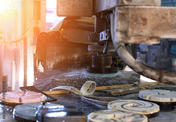 Fototapeta Machine cutting stone tiles in a workshop during daylight hours, showcasing precision craftsmanship and tools