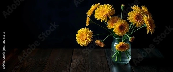 Fototapeta Dark wood table, vibrant yellow chrysanthemums in glass vase, moody lighting, chrysanthemum,  still life