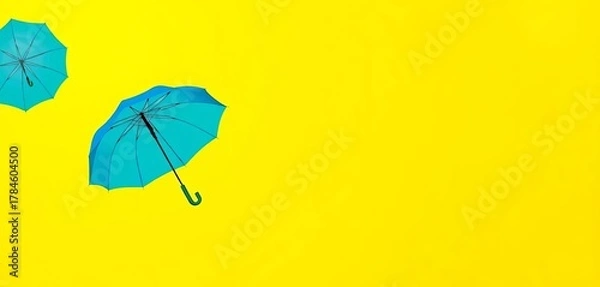 Fototapeta A single blue umbrella stands out against a vibrant yellow background, symbolizing safety and protection,  abstract,  serenity