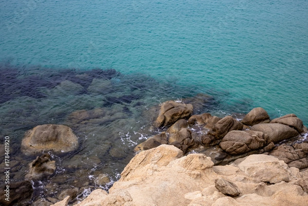 Fototapeta turquoise sea background. top view of rocky sea shore. natural color contrast. beige rocky texture. minimalist seascape with clear transparent