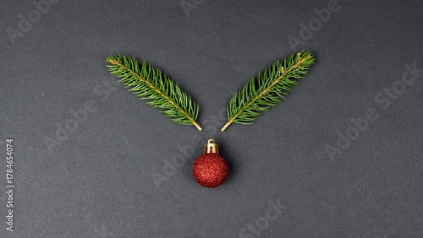 Obraz Reindeer concept made with fir branches and red Christmas ball decoration on black paper background
