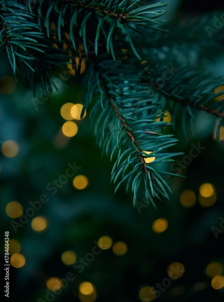 Fototapeta Christmas tree branch and yellow lights garlands blurred in bokeh.