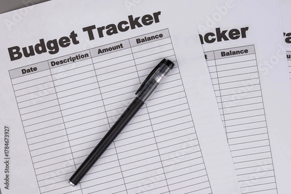 Fototapeta Open daily planner notebook on desk, with organized Monthly Budget tracking table. With dates, categories and expenses. Personal finance management, spending and budgeting habits concept.