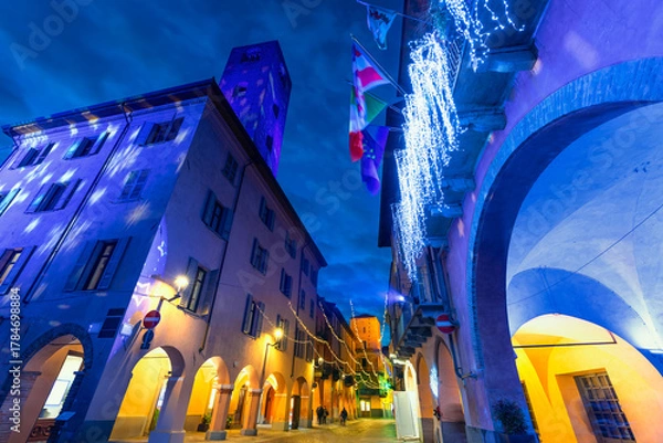 Fototapeta Evening view of the picturesque Italian town of Alba, illuminated with festive Christmas lights.