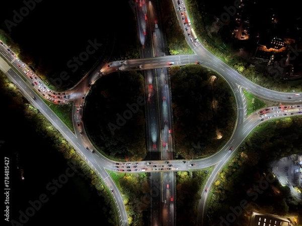 Fototapeta Aerial view over road traffic. Highway and overpass with cars and trucks, interchange, two-level road junction. Top view. Night shooting.