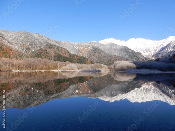 Obraz 青空の青、冠雪の白、紅葉が織り成す晩秋の上高地と大正池に反射する穂高連峰