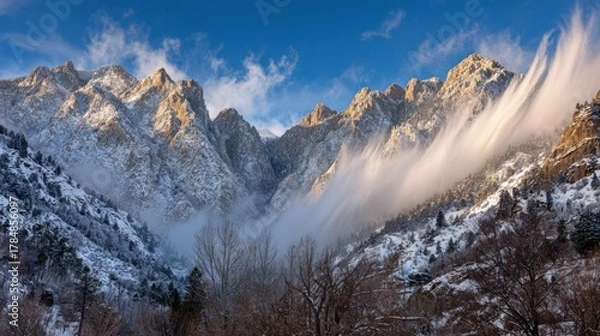 Fototapeta Snowy mountain peaks shrouded in swirling mist