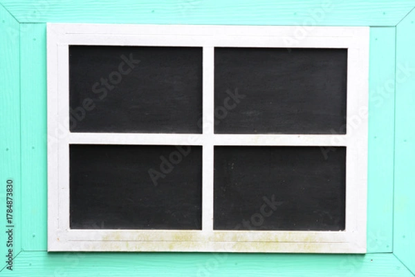 Fototapeta Four black chalkboard panels set within a light blue or mint-colored wooden frame, ideal for a mockup or presentation background.