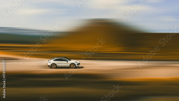 Fototapeta Car driving at high speed. Side view of a fast-moving white car