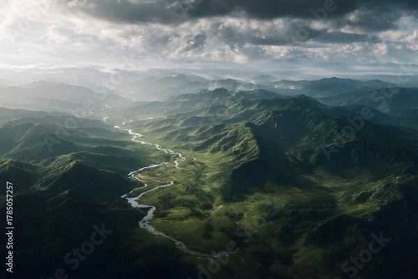 Fototapeta Meandering river flowing through vast green valley