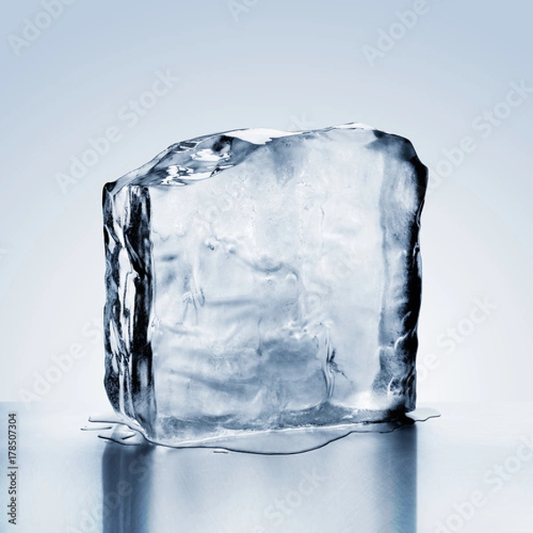 Obraz Cold blue crystal clear frozen block of ice melting to create pool of water on reflective steel surface