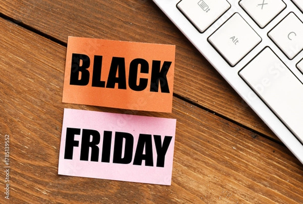 Fototapeta Black Friday words written on a piece of paper. Time for promotions and sales in stores.