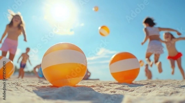 Fototapeta Children playing on sunny beach with colorful beach balls in summer