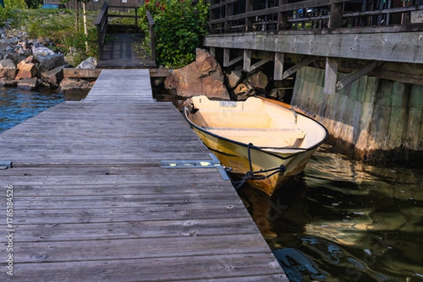 Fototapeta Yellow rowing boat moored at Axmar wooden dock
