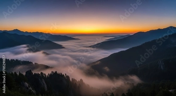 Obraz Dramatic sunset view over mountain range with clouds in the valleys