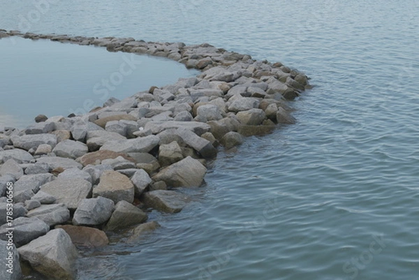 Fototapeta View of an ocean breakwater made by stacking big boulders on top of each other
