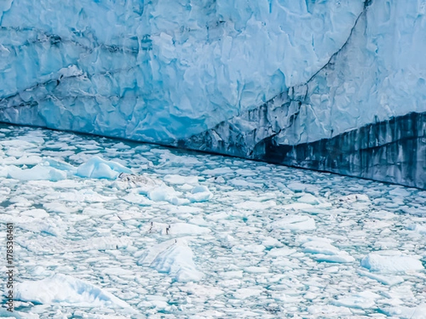 Obraz Majestic Perito Moreno Glacier with snow-capped mountains in Patagonia, Argentina. Vivid blue tones of the ice contrast with the dark slopes, highlighting the raw beauty of nature.
