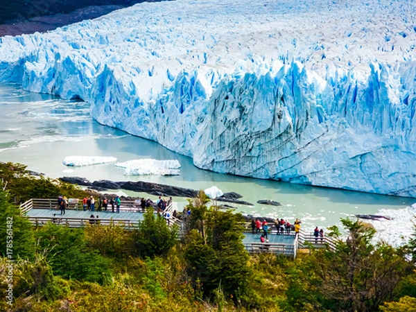 Obraz Majestic Perito Moreno Glacier with snow-capped mountains in Patagonia, Argentina. Vivid blue tones of the ice contrast with the dark slopes, highlighting the raw beauty of nature.