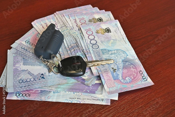 Fototapeta Holding a fan of colorful banknotes in hand during a financial transaction at a local market in the afternoon light