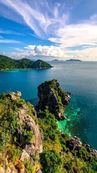 Fototapeta Breathtaking coastal view showcasing lush cliffs, turquoise waters, and distant islands
