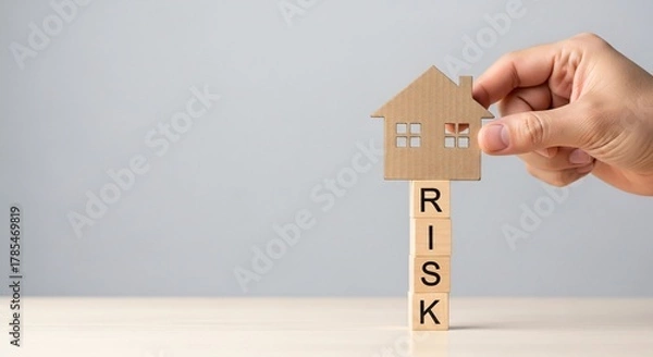 Fototapeta House risk concept Hand holding a paper house on top of wooden blocks with 'RISK'